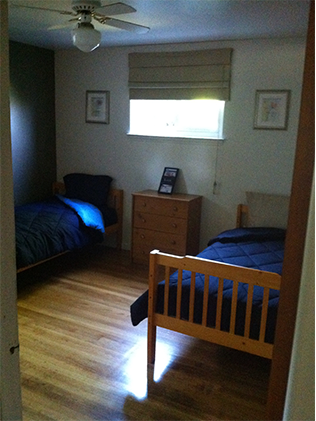 A bedroom with two beds and a dresser.