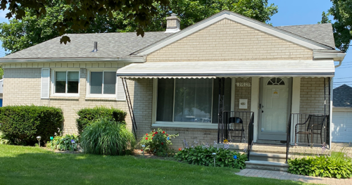 A house with a porch and awning on the front of it