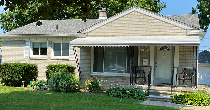 A house with a porch and awning on the front of it.