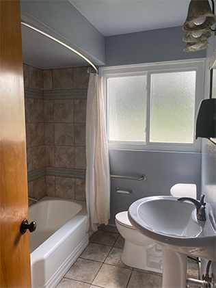 A bathroom with a toilet, sink and bathtub.