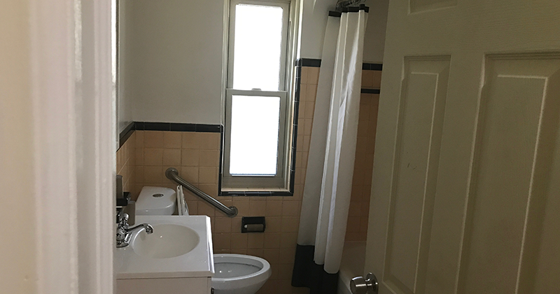 A bathroom with a toilet, sink and window.