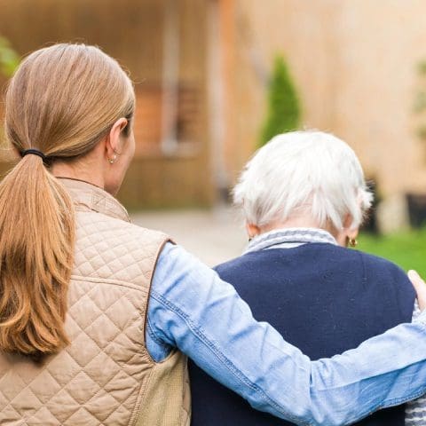 A woman and an older man are standing outside