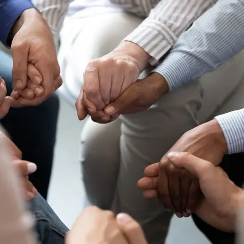 A group of people holding hands in a circle.